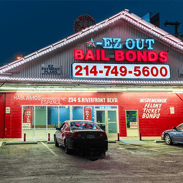 The storefront sign for A-EZ Out Bail Bonds taken at night, in Dallas, Texas